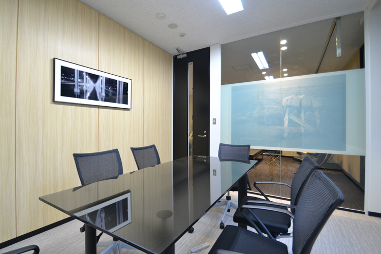 ガラス天板のテーブルと透明ガラスの間仕切りが印象的な会議室