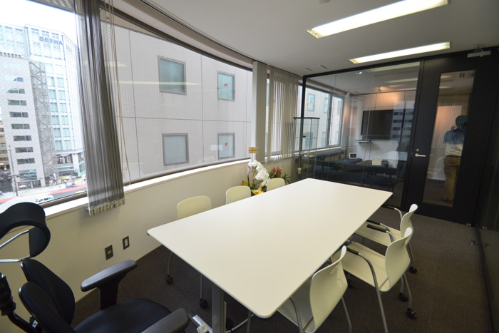 全面ガラスと壁かけTVでオープンな空間を実現したオフィスデザイン事例