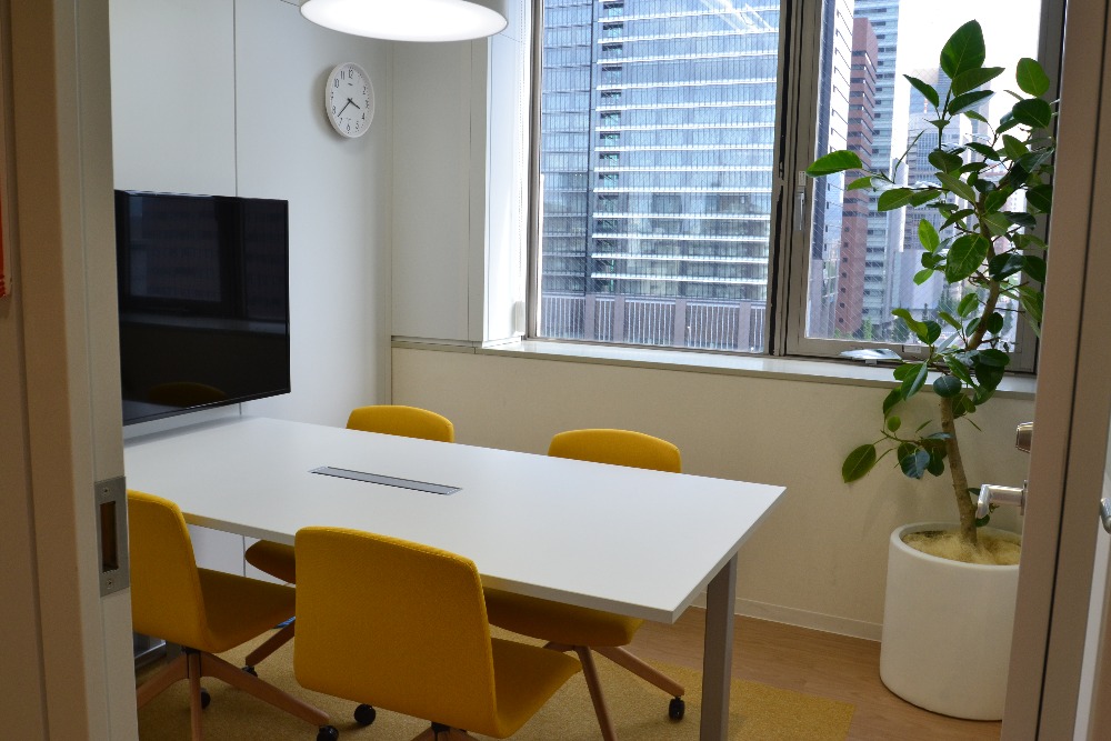 白と黄色が調和する明るく柔らかな雰囲気の会議室