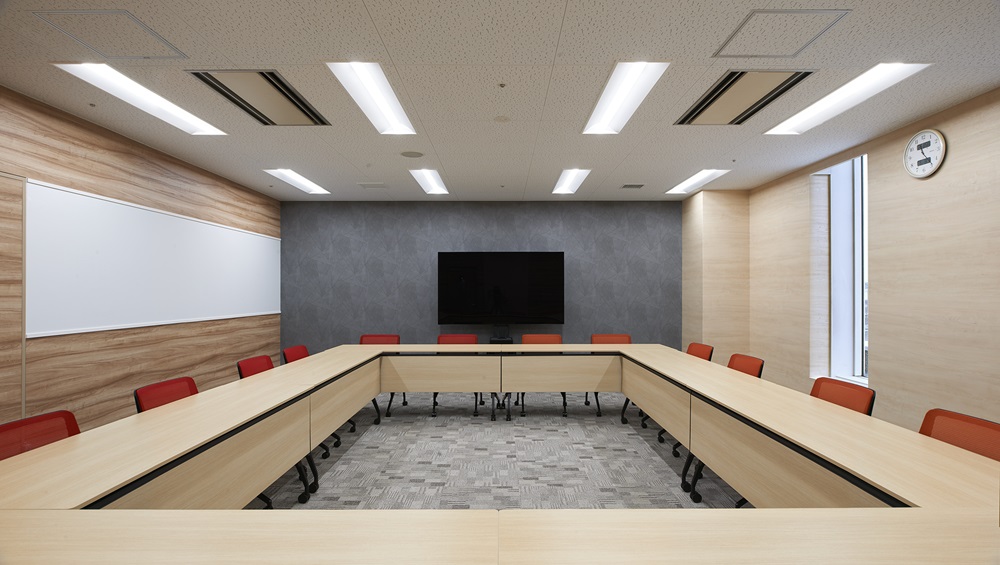 レッド＆オレンジのチェアが映える、シンプルで明るい大会議室