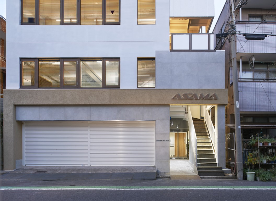 周りの景色に馴染む、明るい自社ビルの外壁