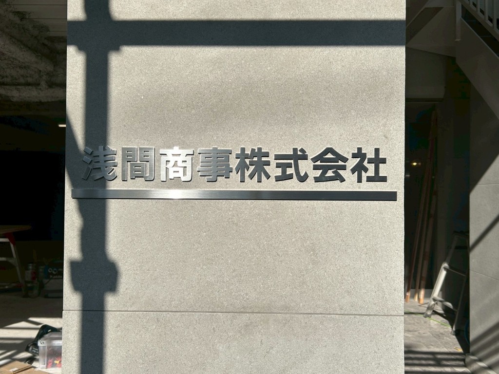 周りの景色に馴染む、明るい自社ビルの外壁