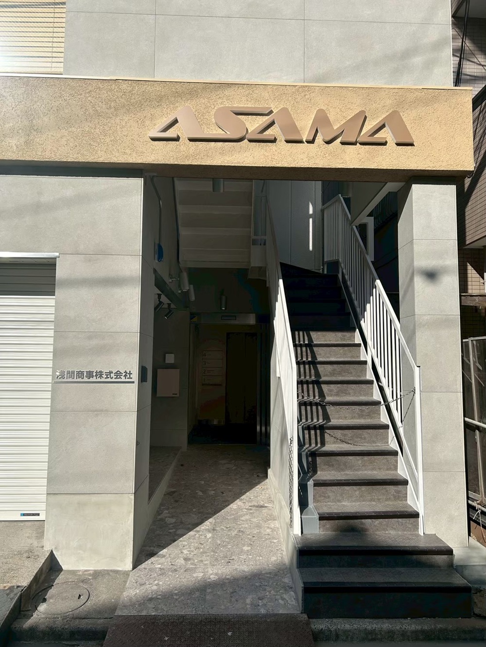 周りの景色に馴染む、明るい自社ビルの外壁